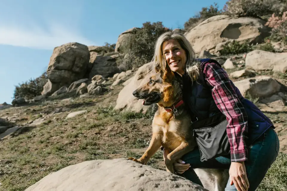 Owner running hands through a dog&#x27;s fur checking for ticks after a hike